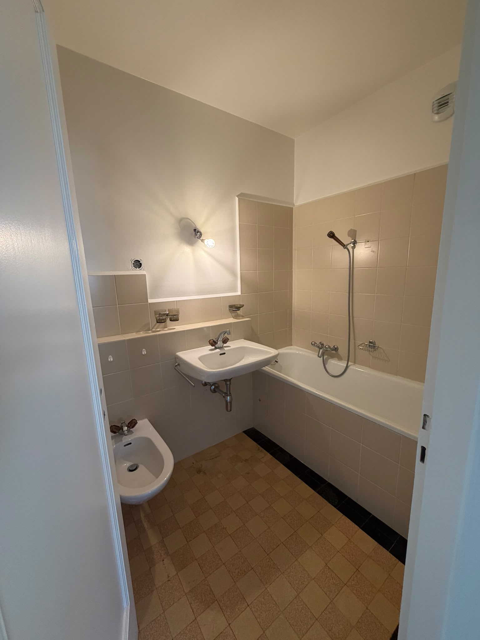 Salle de bains : murs et plafond repeints en blanc au-dessus du carrelage beige existant