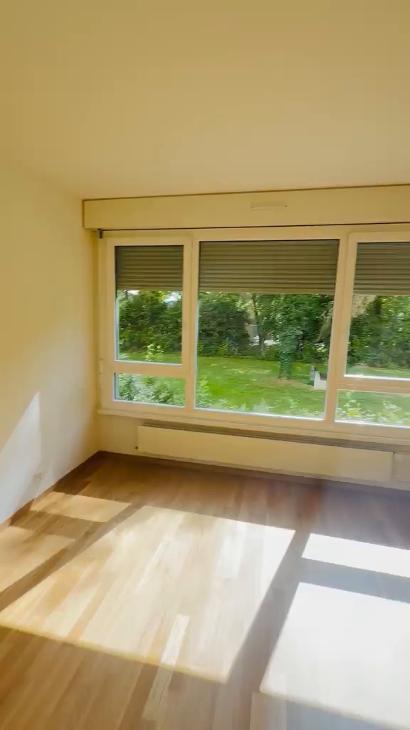 Séjour aux murs blancs et plafond lisse, fenêtres sur jardin, parquet en chêne